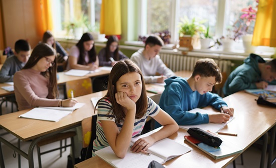 Teen girl in classroom, daydreaming