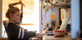 Young girl siting at desk in front of computer