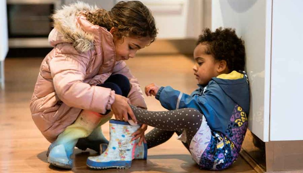 Sister helping her younger brother