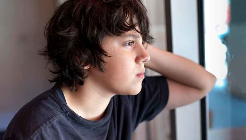 Teenager looking out a window