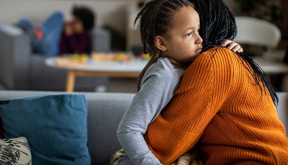 Mother comforting son on couch