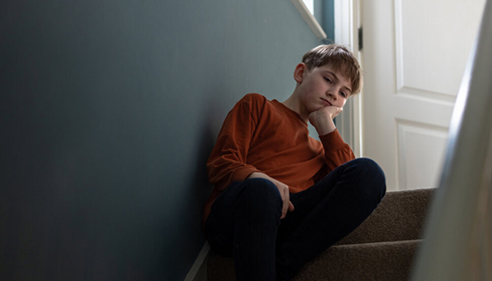 teen boy deep in thought, sitting in stairway alone