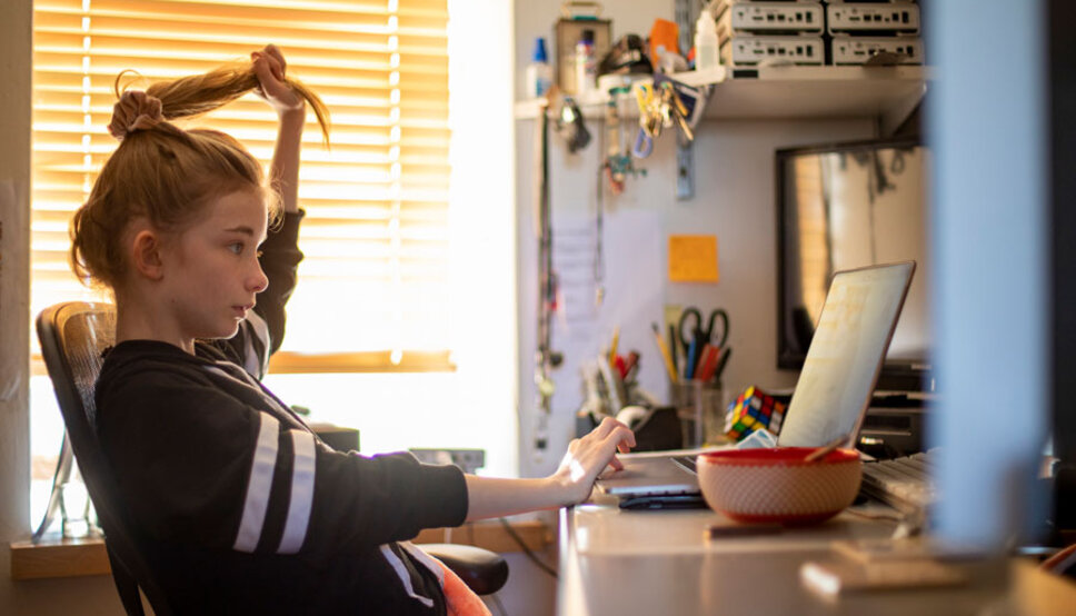 Young girl siting at desk in front of computer