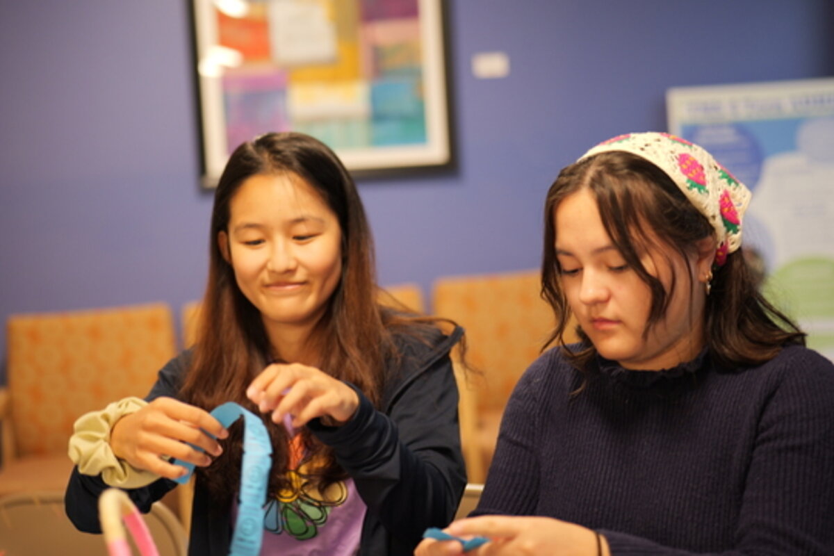 A woman and a girl engage in arts and crafts.