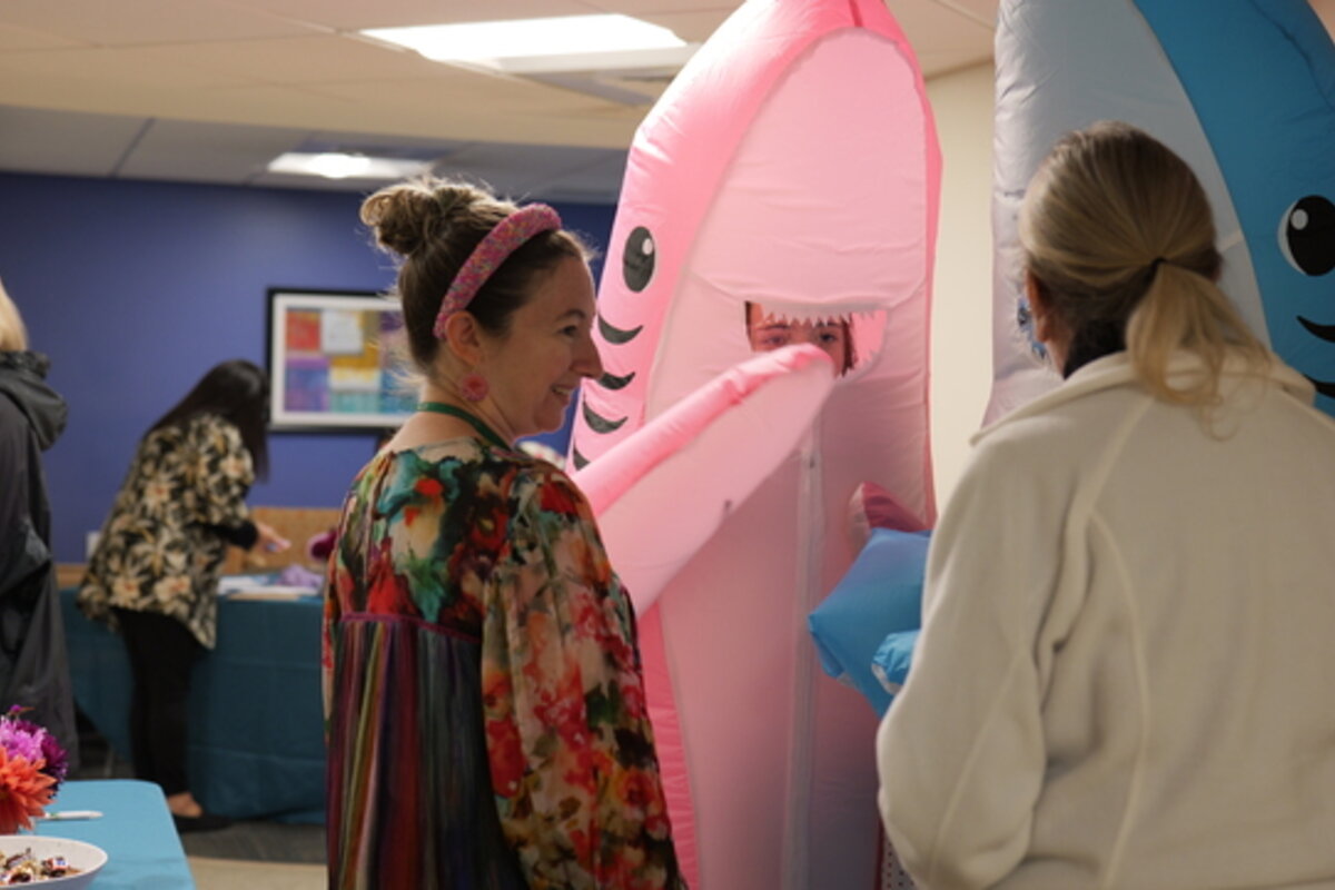 People surrounded by blow-up cartoon animals.