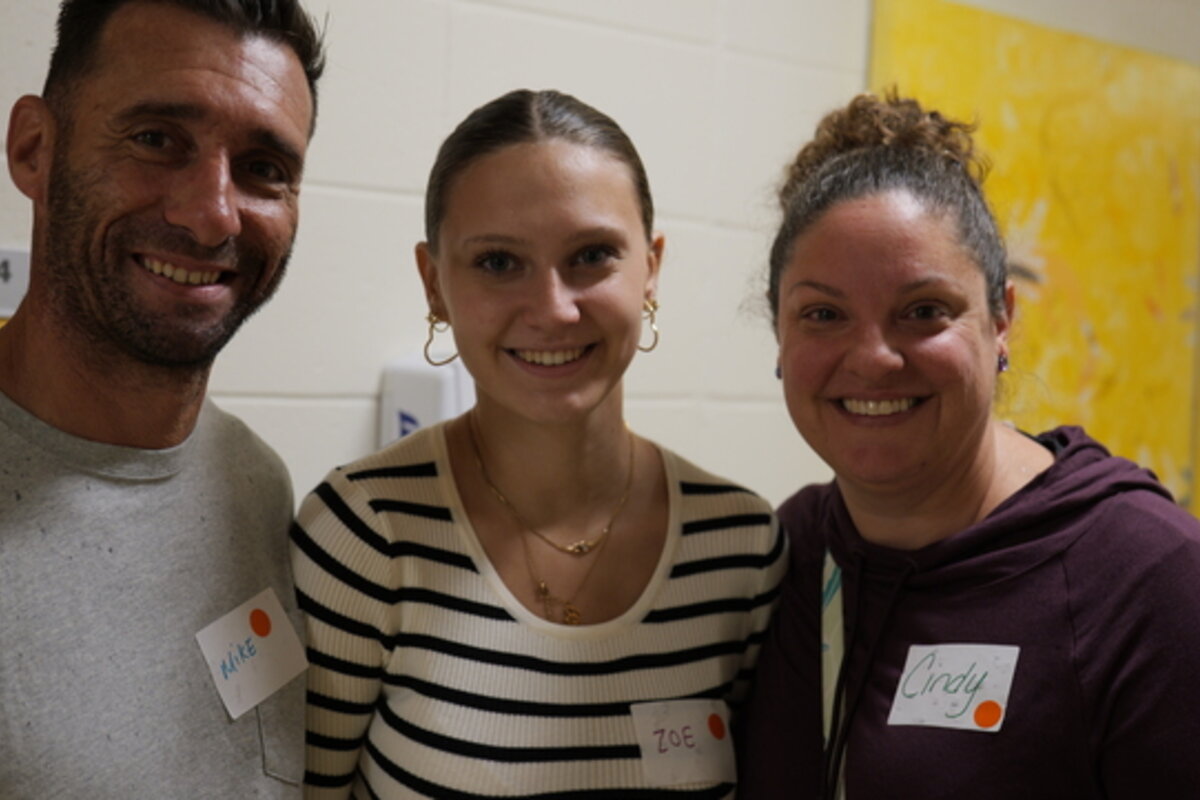 Three people smile at the camera.