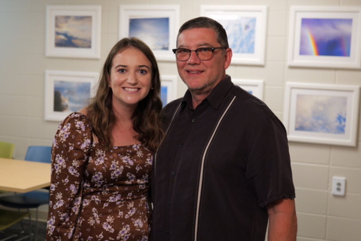 Two people smile at the camera.