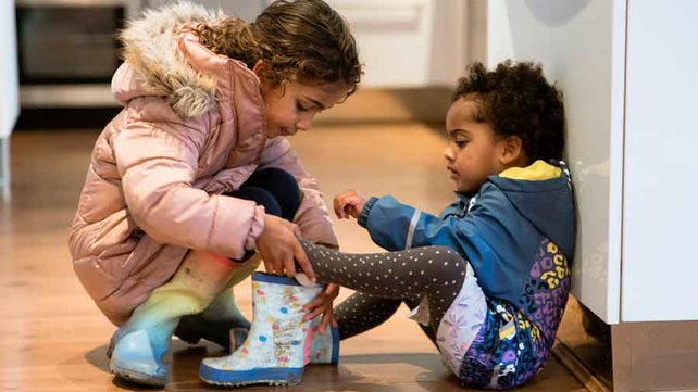 Sister helping her younger brother