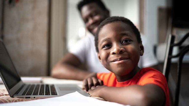 Child on laptop with father